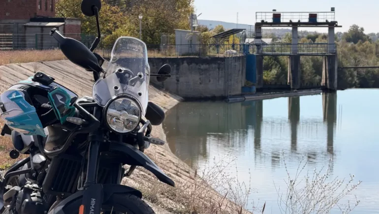 Royal Enfield Himalayan 450 Mana Black parked by a reservoir in Romania after its first 200 km
