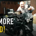 Dragos smiling behind the new Isotta tall windscreen on his black Royal Enfield Himalayan 450 in the garage