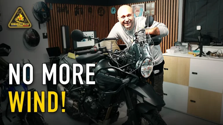 Dragos smiling behind the new Isotta tall windscreen on his black Royal Enfield Himalayan 450 in the garage