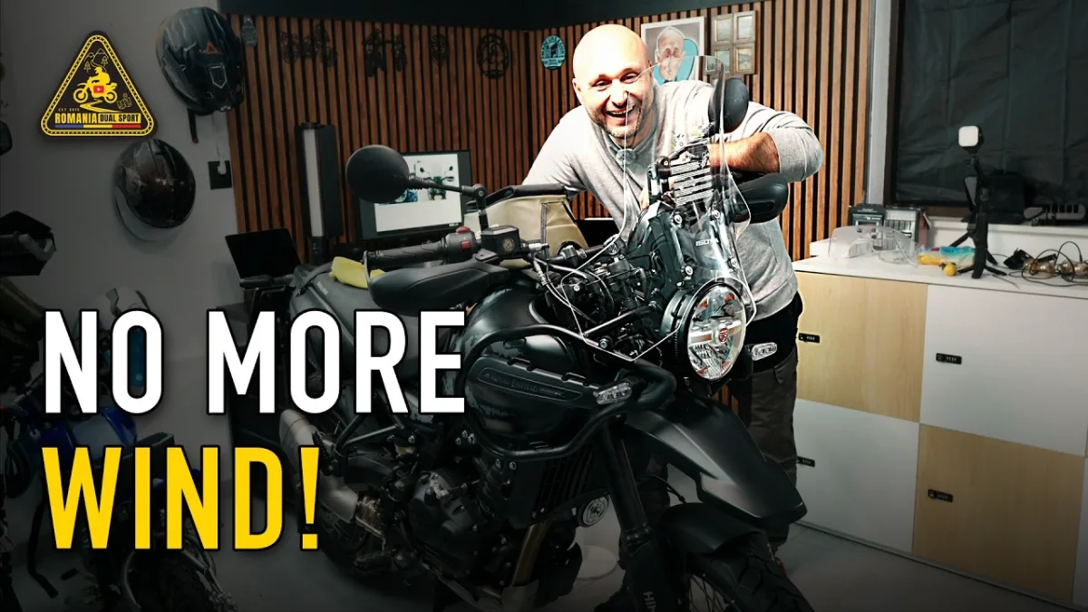 Dragos smiling behind the new Isotta tall windscreen on his black Royal Enfield Himalayan 450 in the garage