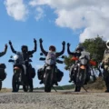 Adventure riders celebrating on a mountain road