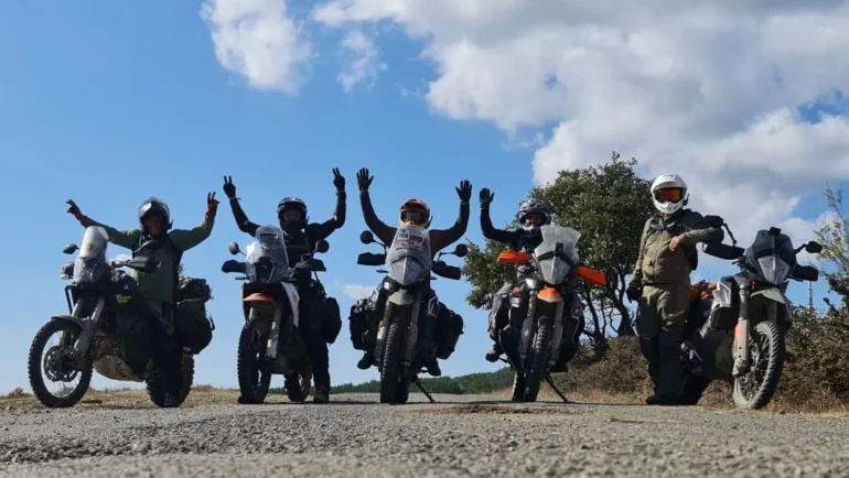 Adventure riders celebrating on a mountain road